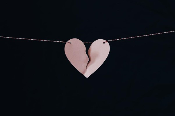 A Pink Paper Heart Torn from the Middle and Hanging from a String